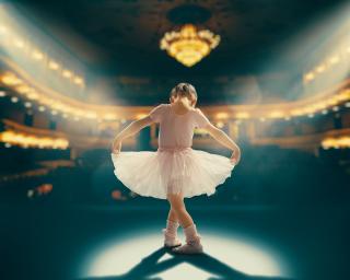 Child girl in a pink tutu dancing on the stage. Little girl is studying ballet.