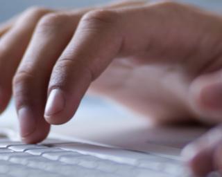 This is an image of a person typing on a computer. 