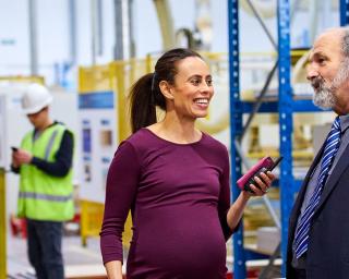 Pregnant Woman at Work in Warehouse with Boss