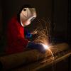 A welder working on a section of pipe. 